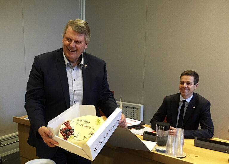 Bilde av Hans Fredrik Grøvan og Knut Arild Hareide som mottar kake fra blindeforbundet