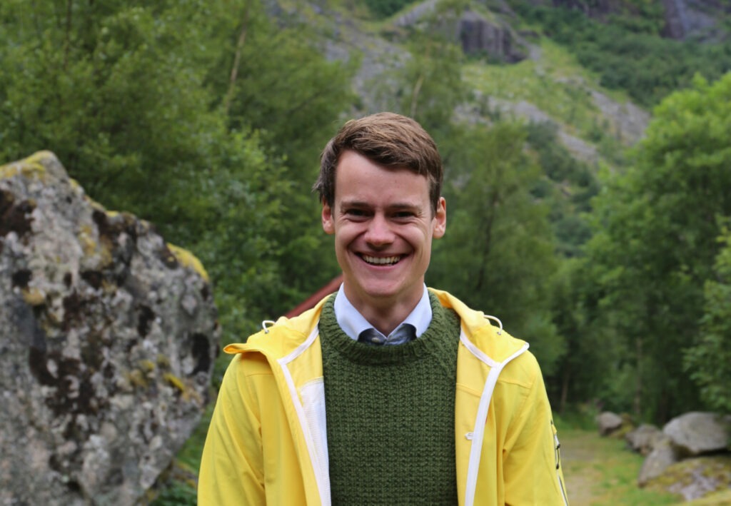 Portrett av Tore Storehaug ikledd gul regnjakke. Han smiler.