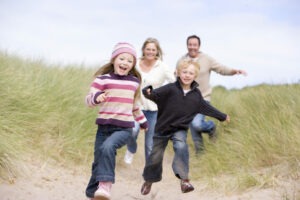 En familie som løper på stranden, Foto: Colourbox