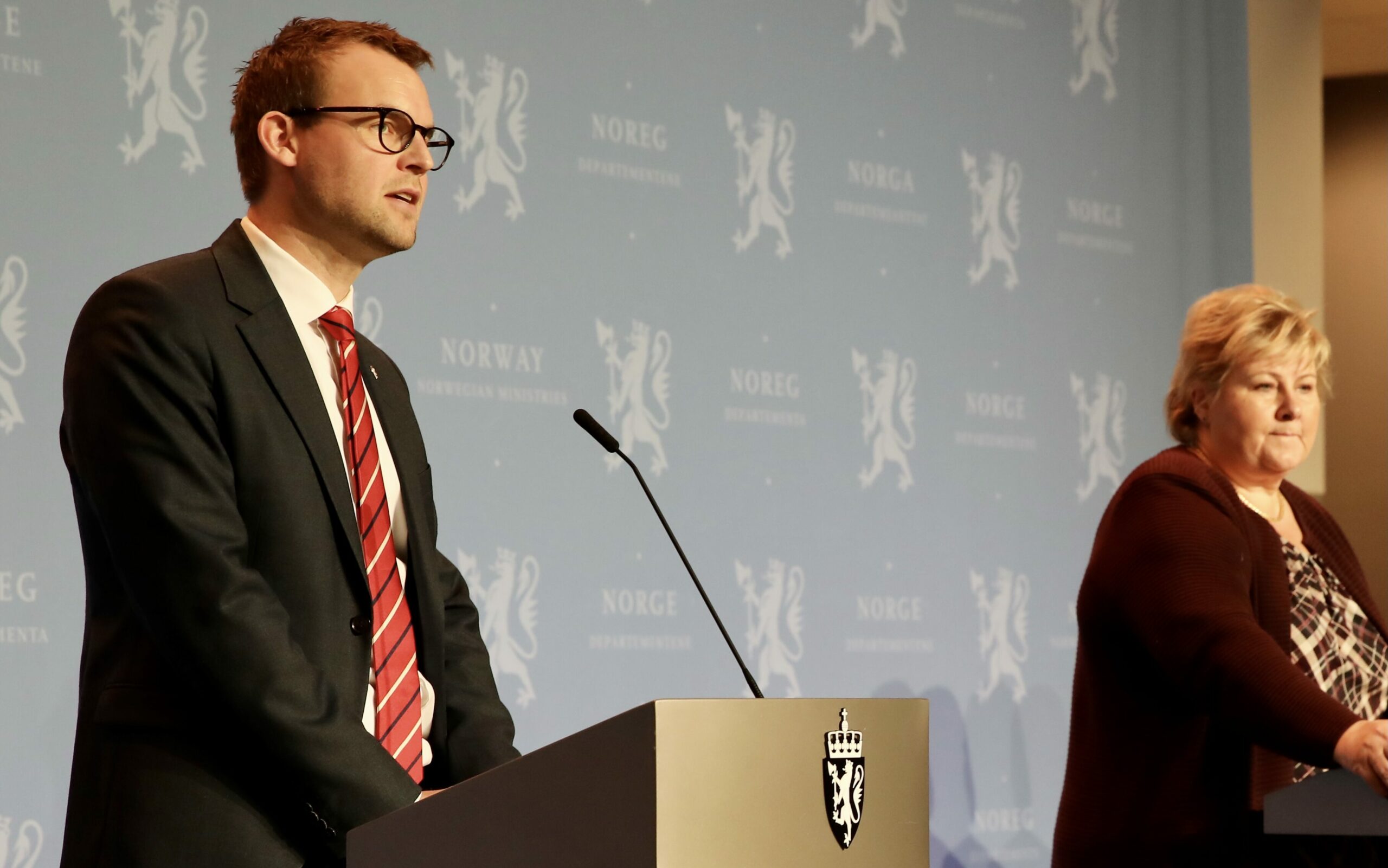 Kjell Ingolf Ropstad bak en talerstol ved siden av Erna Solberg på pressekonferanse