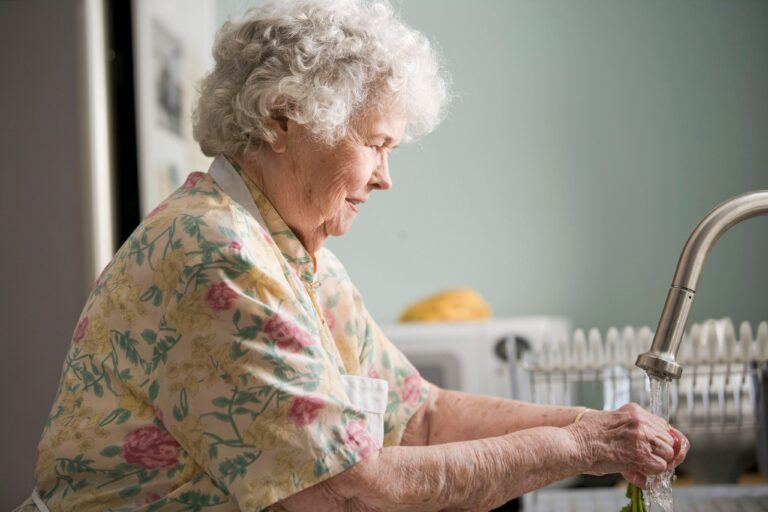 Eldre dame ved kjøkkenbord