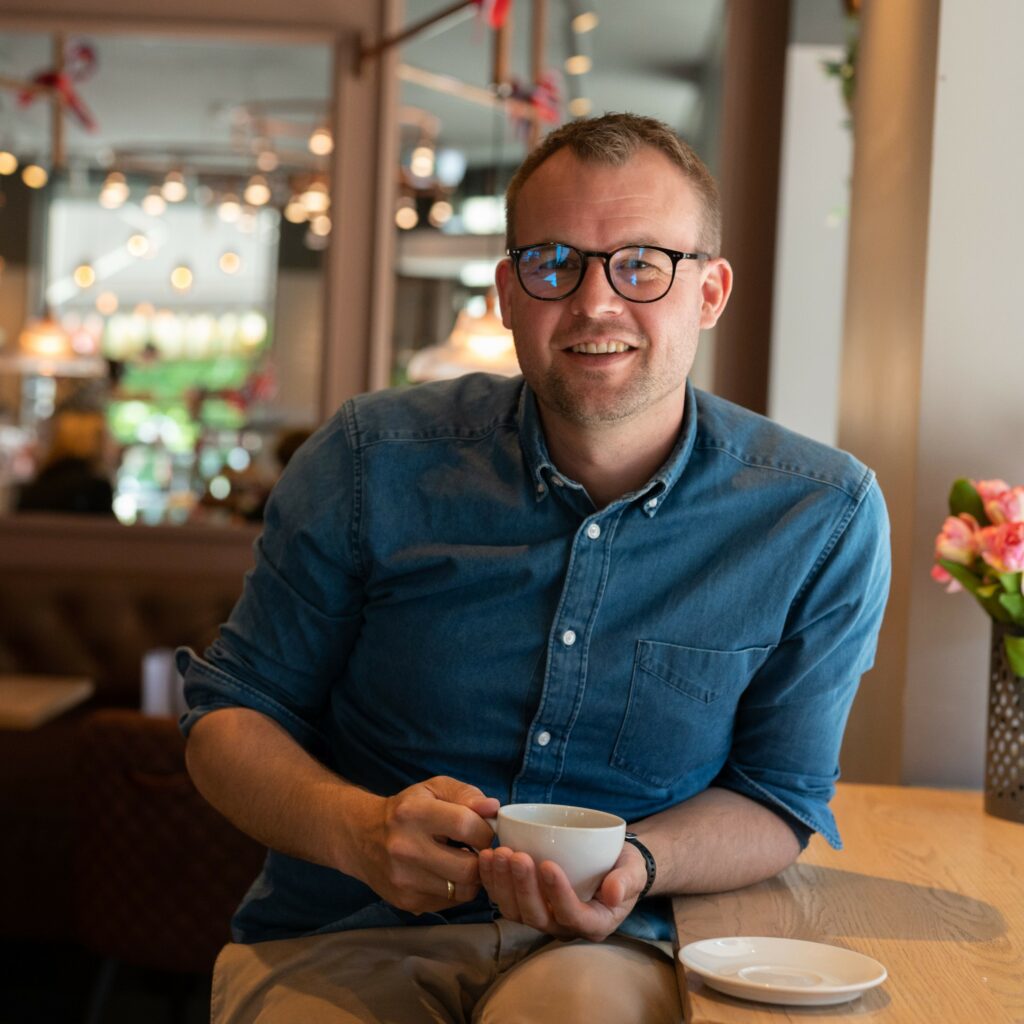 Kjell Ingolf Ropstad sitter på en kafé og drikker kaffe.