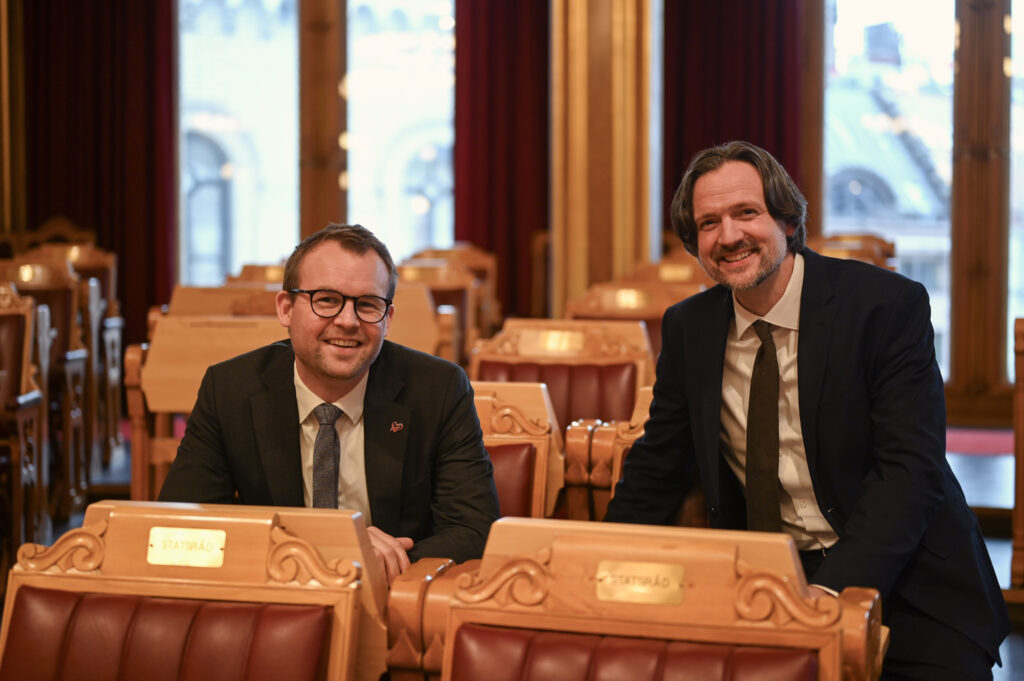 Kjell Ingolf Ropstad og Dag Inge Ulstein sitter i stortingssalen og smiler til kamera