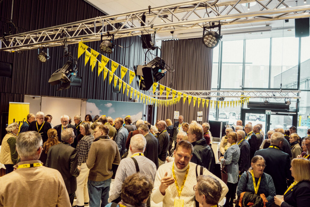 Flere KrF-ere står i foajeen utenfor konferansesalen og snakker sammen i en av pausene. 