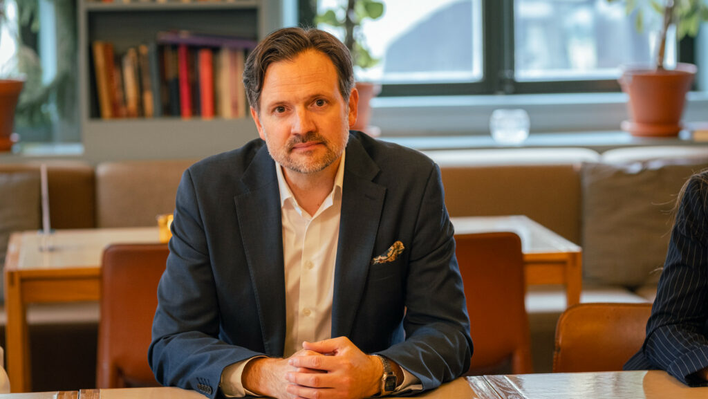 Dag-Inge Ulstein sitter ved et bord, med armene på bordet, og ser inn i kameraet